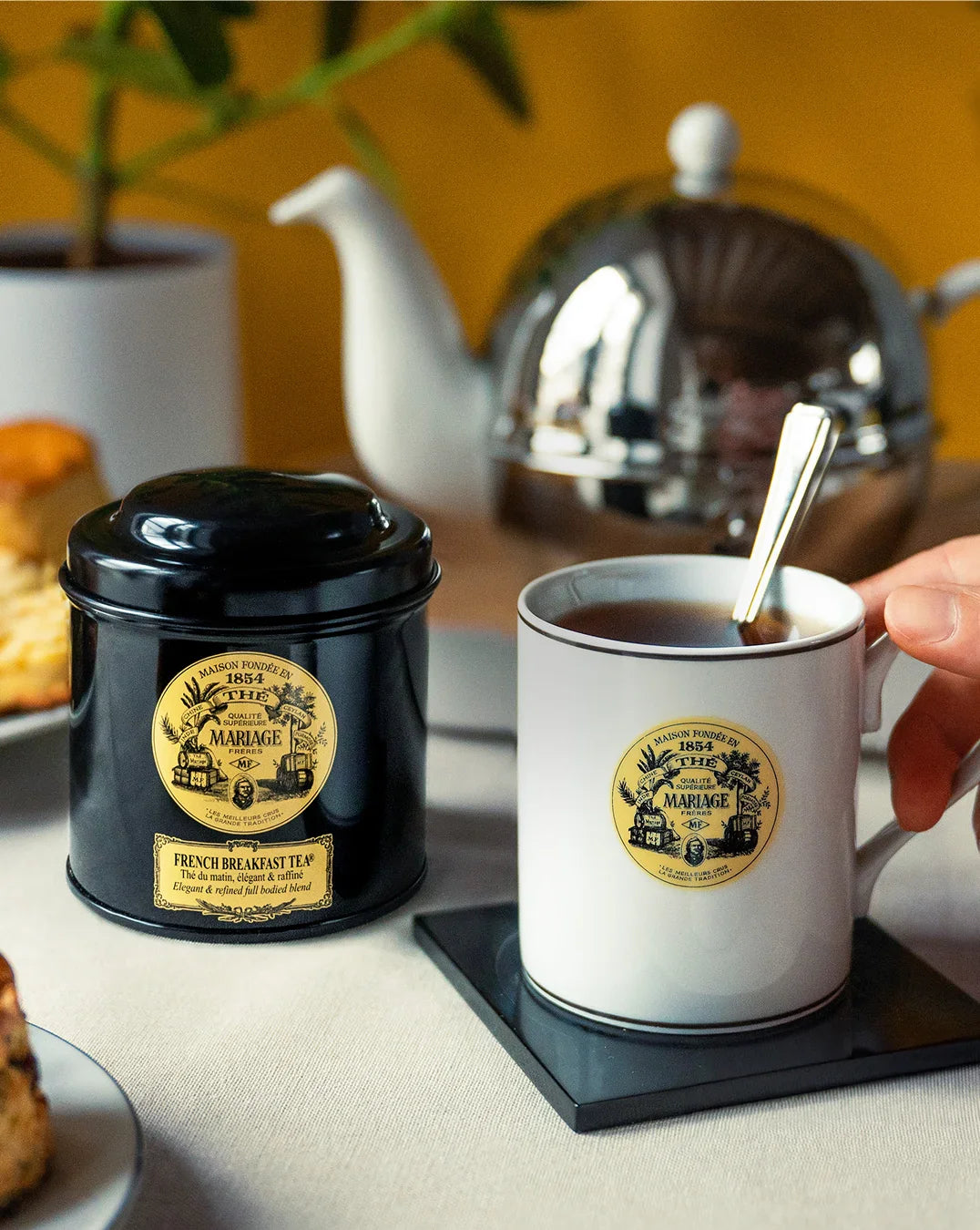Mariage Frères Teedose French Breakfast Tea neben einer Tasse Tee und Teekanne