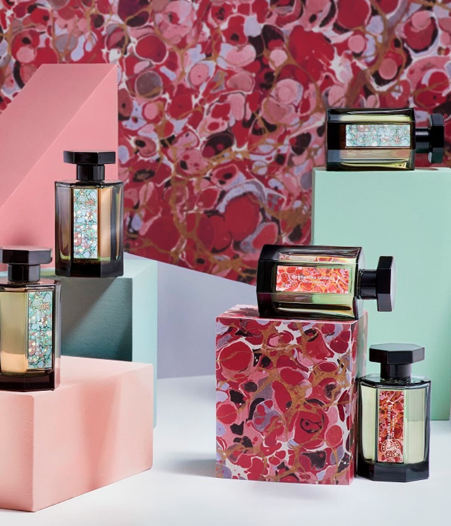 L'Artisan Parfumeur Les Paysages, Flakons auf Podesten vor rot marmoriertem Papier