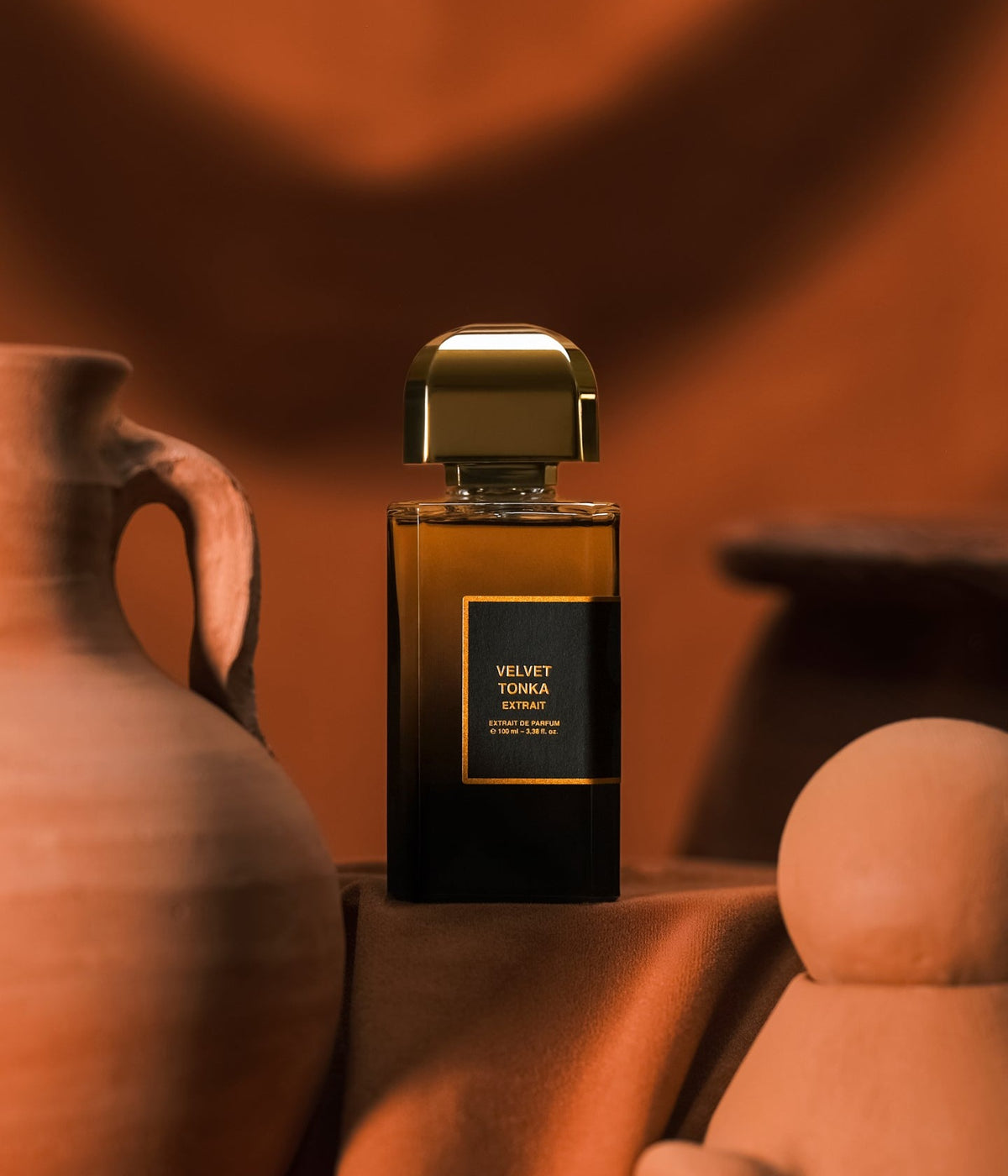 BDK Parfums Extrait de Parfum Velvet Tonka zwischen Tongefäßen vor terrakottafarbenem Stoff