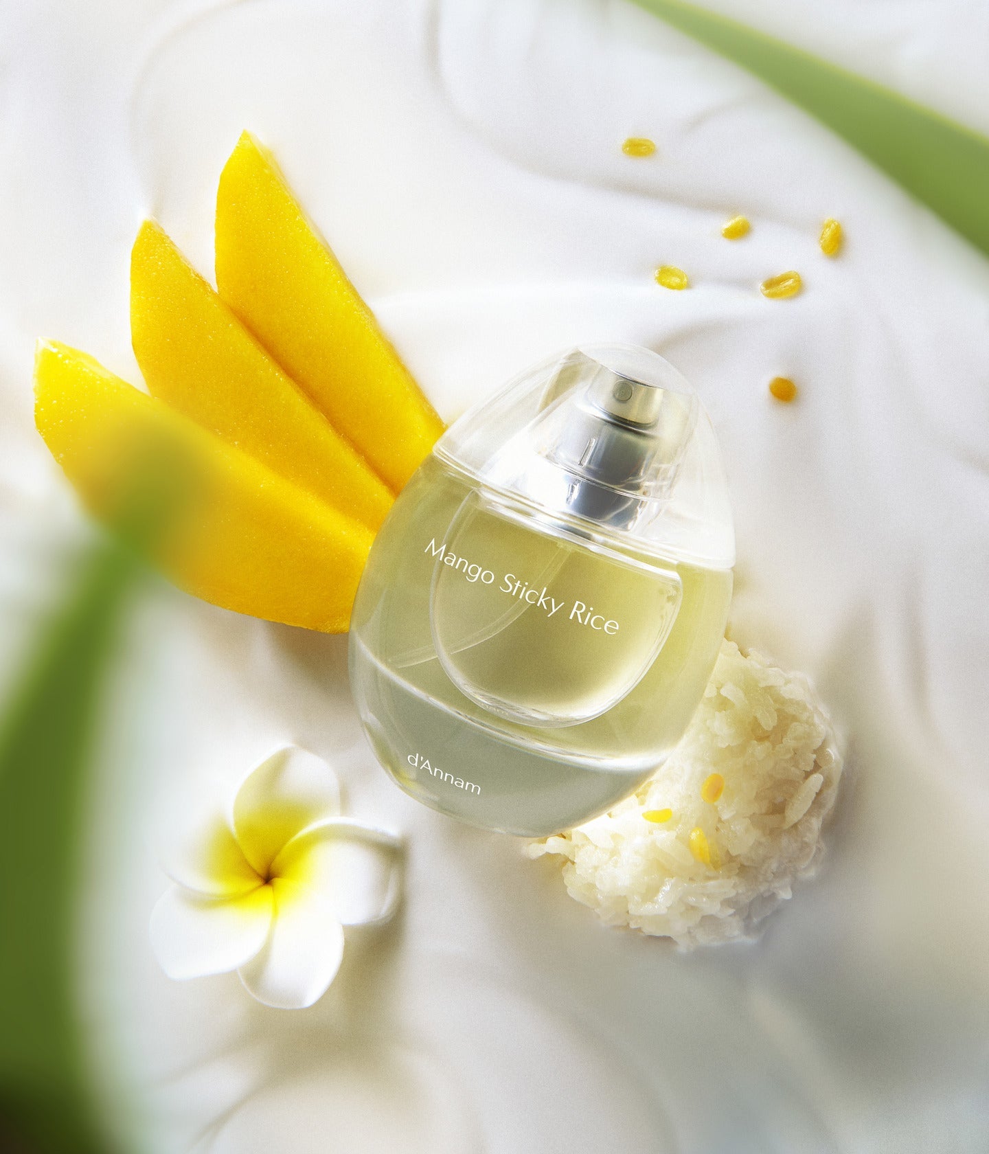Eau de Parfum Mango Sticky Rice von d’Annam mit Mangoscheiben und Frangipaniblüte