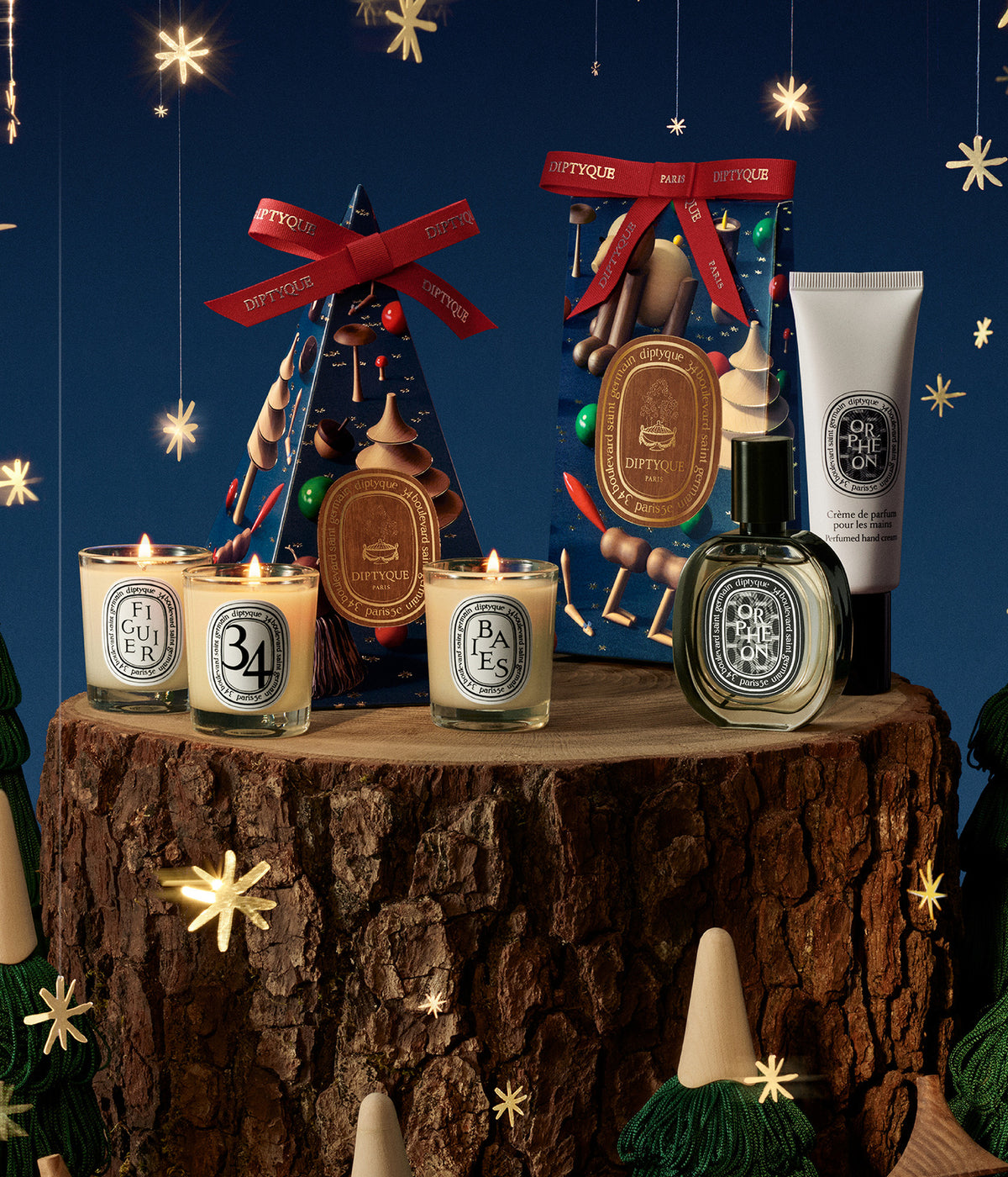 Diptyque Mini-Duftkerzen, Geschenkschachtel mit Schleife, Flakon und Handcreme auf einem Baumstumpf