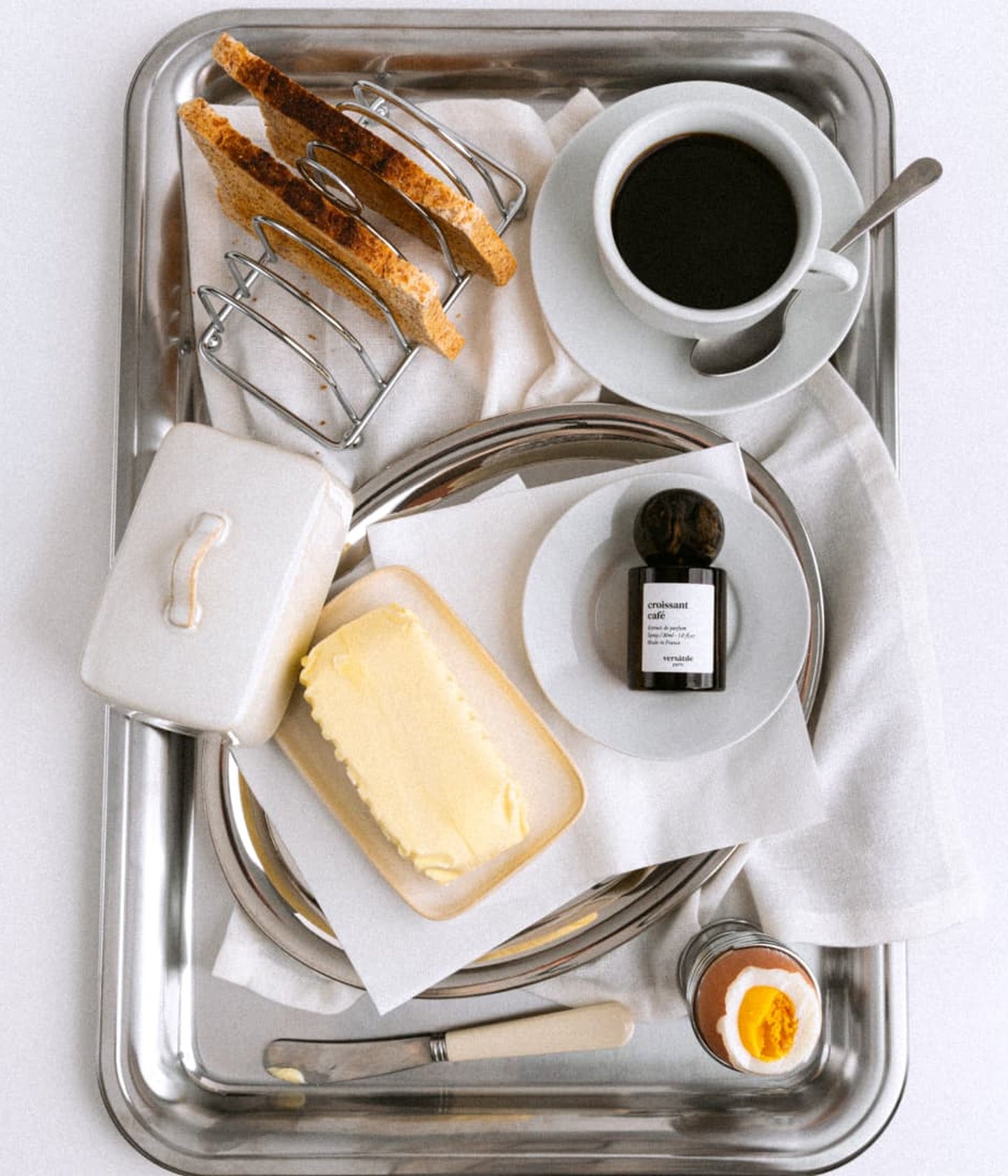 Croissant Café von Versatile Paris neben Kaffee und Butter auf dem Tablett
